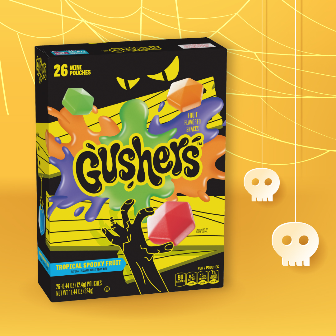 Tropical Spooky Fruit Gushers Minis box displayed on a yellow background with spider web and skull illustrations.
